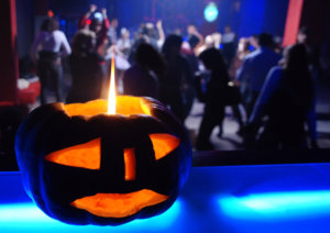 beginnings-treatment-centers-7-ways-to-have-a-sober-halloween-image-of-pumpkin-candle-with-halloween-dance-in-background