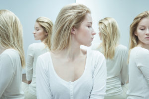 beginnings-treatment-centers-is-addiction-a-disease-or-a-choice-article-image-of-woman-with-mirror-images-of-herself-around-her