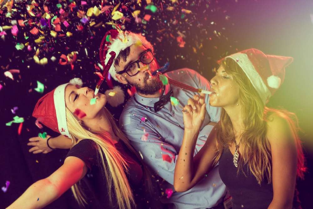 beginnings-treatment-how-can-i-get-through-the-holidays-sober-article-image-of--three-young-people-blowing-party-whistles-at-a-new-year-s-eve-party-337034882
