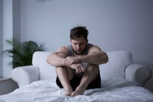 beginningstreatment-five-traits-of-an-addictive-personality-article-image-of-man-after-mental-breakdown-sitting-in-bed-312036692