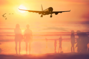 beginnings treatment image of plane landing over beach scene 537164014