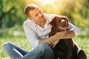 beginningstreatment-controlling-the-committee-in-your-head-article-photo-of-young-guy-with-retriever-on-walk-in-summer-park-295882361