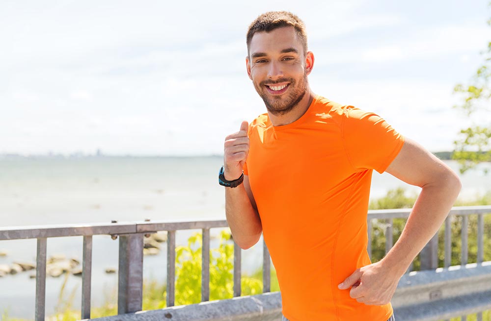 beginningstreatment-healthy-coping-mechanisms-for-your-recovery-article-photo-of-fitness-sport-people-technology-and-healthy-lifestyle-concept-smiling-young-man-with-heart-300552362