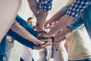 beginningstreatment-what-is-smart-recovery-article-photo-low-angle-cropped-view-of-colleagues-putting-their-hands-on-top-of-each-other-wearing-casual-645806167