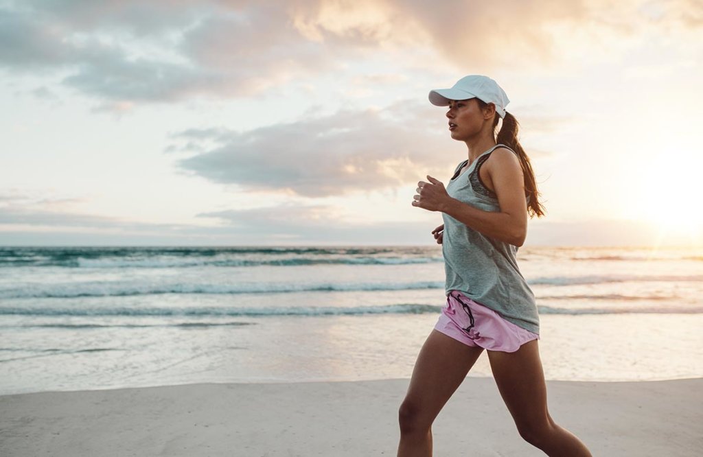 beginningstreatment-how-exercise-helps-you-stay-sober-article-photo-side-view-shot-of-beautiful-young-woman-in-sportswear-jogging-on-beach-female-runner-jogging-on-569531539