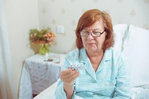 beginningstreatment-substance-abuse-in-aging-populations-article-photo-senior-woman-in-glasses-sitting-on-bed-at-home-taking-pills-sick-old-caucasian-red-hair-780207298