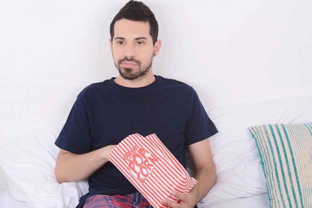 beginningstreatment-five-addiction-films-you-have-probably-never-heard-of-article-photo-young-man-eating-popcorn-and-watching-movies-relaxed-on-bed-indoors-1020508735