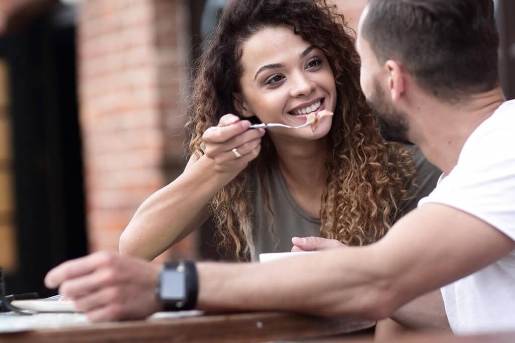 beginningstreatment-what-is-it-like-to-date-sober-article-photo-young-couple-enjoying-coffee-at-a-street-cafe-and-laughing-1033738312