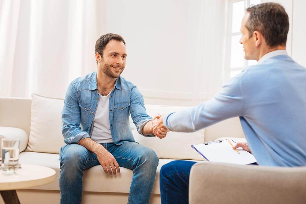 beginningstreatment-detox-photo-nice-session-attractive-confident-male-patient-saying-goodbye-to-doctor-while-sitting-on-the-couch beginningstreatment-detox-photo-nice-session-attractive-confident-male-patient-saying-goodbye-to-doctor-while-sitting-on-the-couch