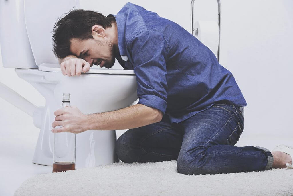 beginningstreatment-what-is-alcohol-poisoning-article-photo-drunk-man-with-wine-bottle-in-toilet-isolated-on-white