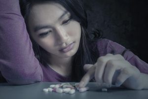 beginningstreatment-what-is-gabapentin-portrait-teenager-girl-choosing-pills