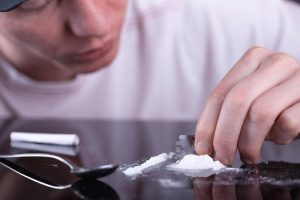 beginningstreatment-the-difference-between-crack-and-cocaine-photo-of-a-man-cutting-cocaine-using-a-blade
