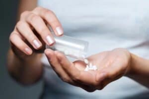 Woman holding many pills in her hand