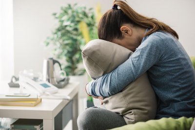 Woman crying into pillow