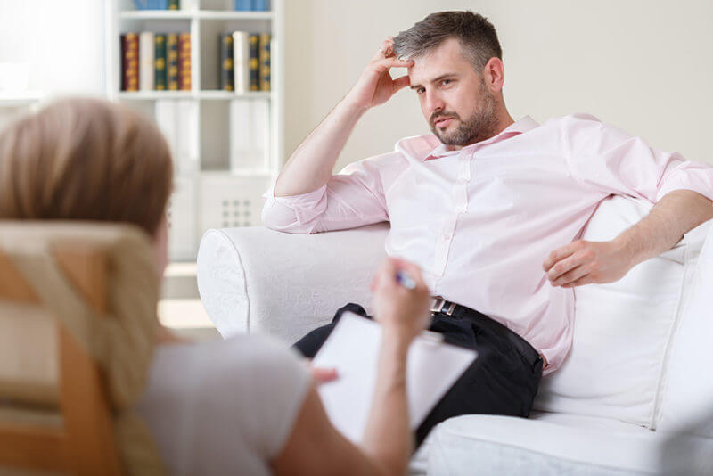 man in therapy talking to doctor