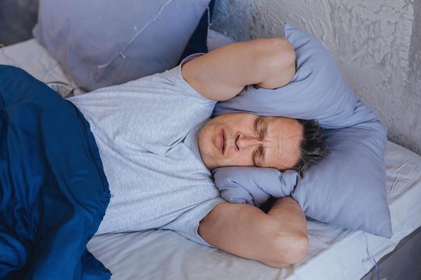 Man lying in bed feeling irritated experiencing marijuana withdrawal symptoms