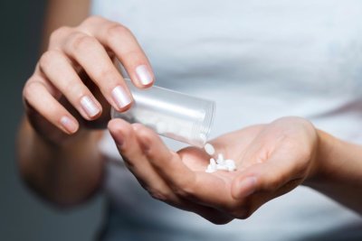 Girl holding many prescription pills in her hand