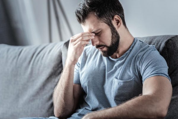 Man having a headache from withdrawal symptoms