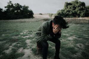 Man with depression sitting in a field